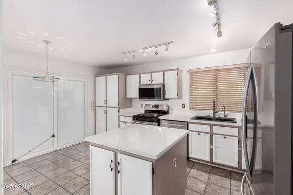 a kitchen with a sink a stove and cabinets