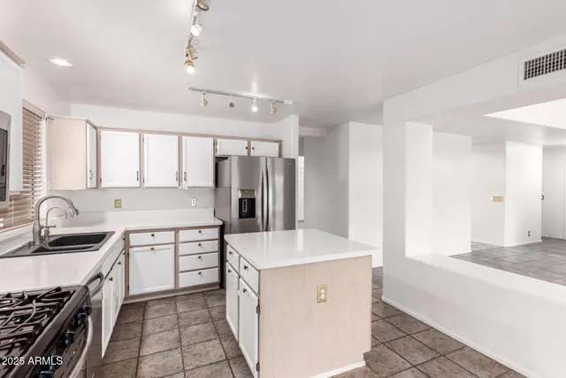 a kitchen with granite countertop a sink stove and refrigerator