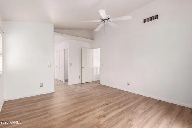 a view of an empty room with wooden floor