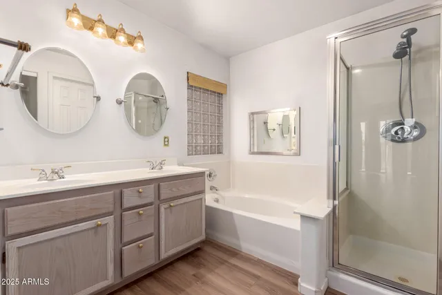 a bathroom with a double vanity sink mirror and bathtub
