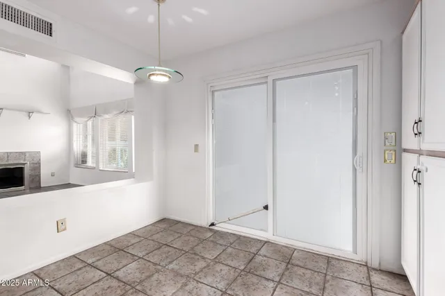 a view of an empty room with window and cabinet