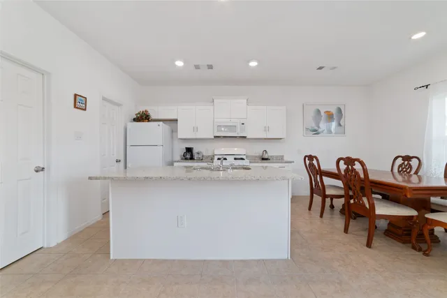 a kitchen with white cabinets sink and white appliances