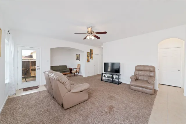 a living room with furniture and a ceiling fan