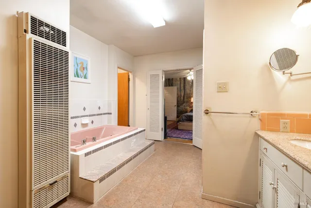 a bathroom with a tub sink and mirror