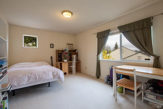 a bedroom with a bed and a flat tv screen on the dresser