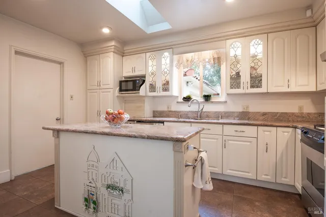 a kitchen with granite countertop white cabinets and white appliances