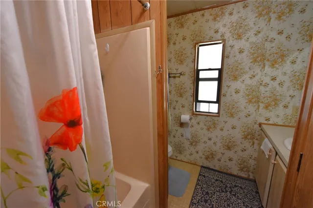 a bathroom with a sink a mirror and next to a window