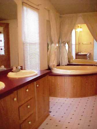 14741 Douglas Road Yakima, WA 98908 - Photo 14 of 18 a bathroom with a sink mirror and a bathtub next to a window