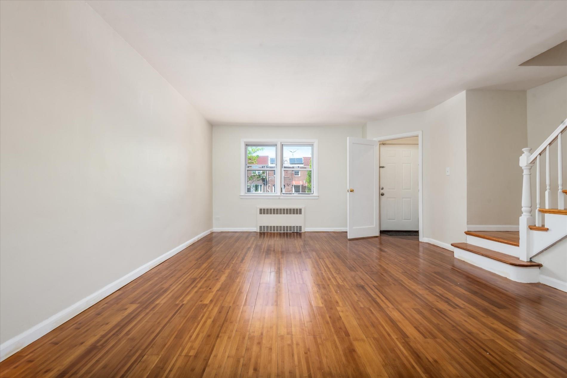 150-20 77th Avenue Queens, NY 11367 - Photo 5 of 24 an empty room with wooden floor and windows