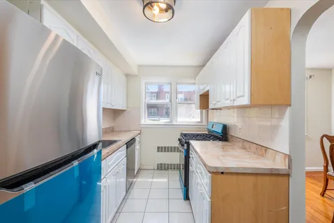 a kitchen with a sink a stove cabinets and a window