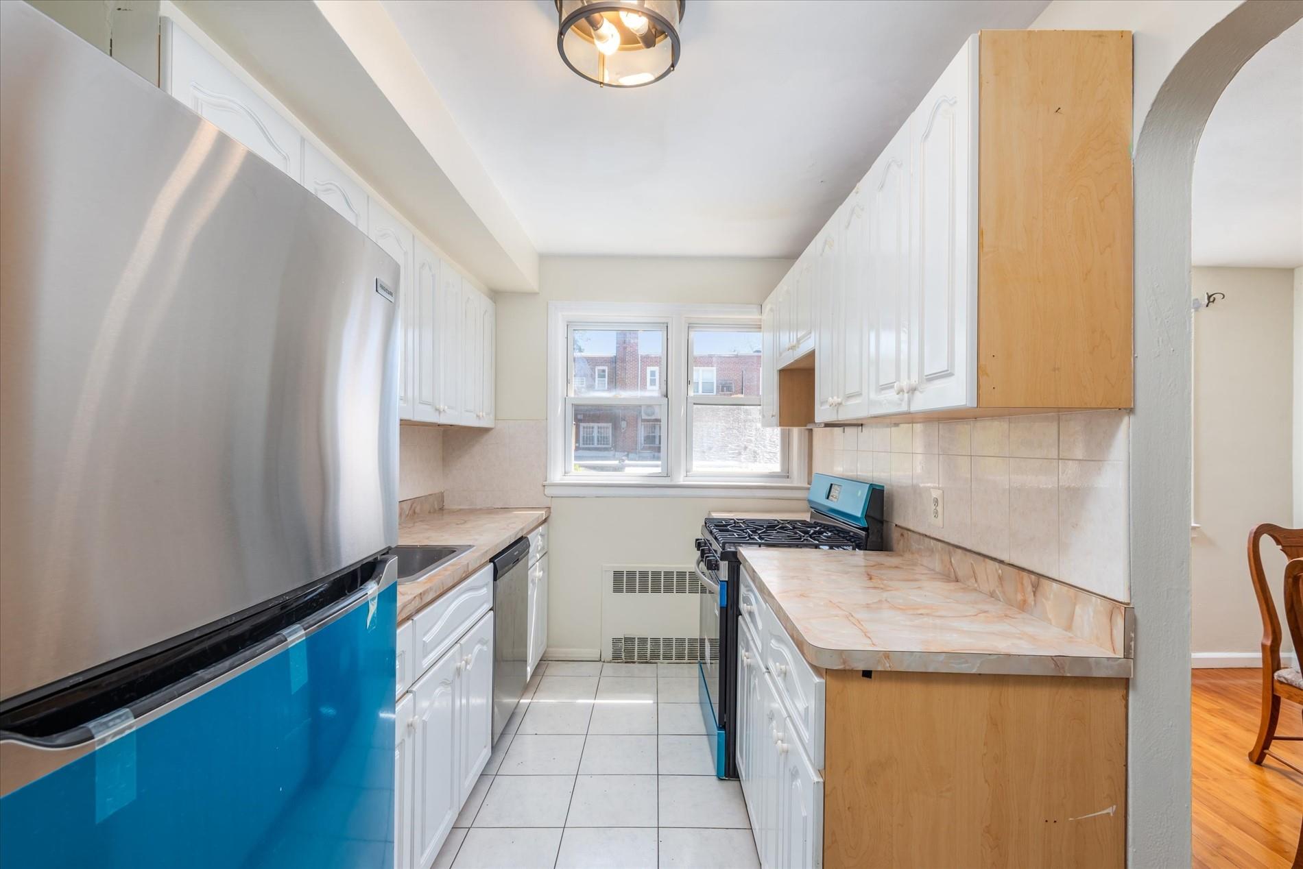 150-20 77th Avenue Queens, NY 11367 - Photo 10 of 24 a kitchen with a sink a stove cabinets and a window