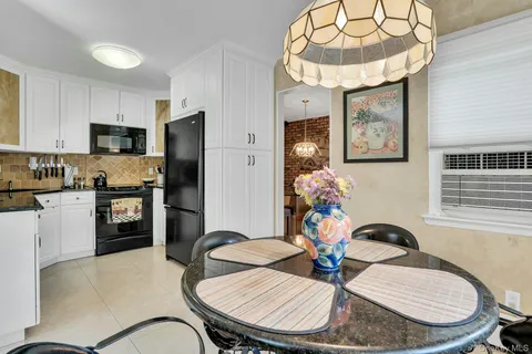 a kitchen with stainless steel appliances a dining table and chairs