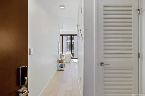 a kitchen with stainless steel appliances a dining table chairs and a refrigerator