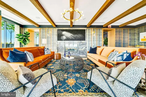 a living room with furniture a chandelier and a floor to ceiling window