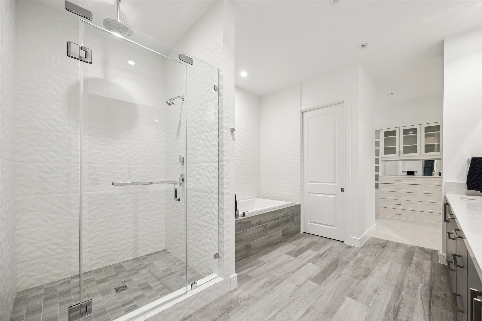4521 San Felipe Street, Unit 23045 Houston, TX 77027 - Photo 14 of 25 Another view of the primary bathroom, note the shower is tiled from the floor to the ceiling. The custom built primary closet is in the back of this picture.