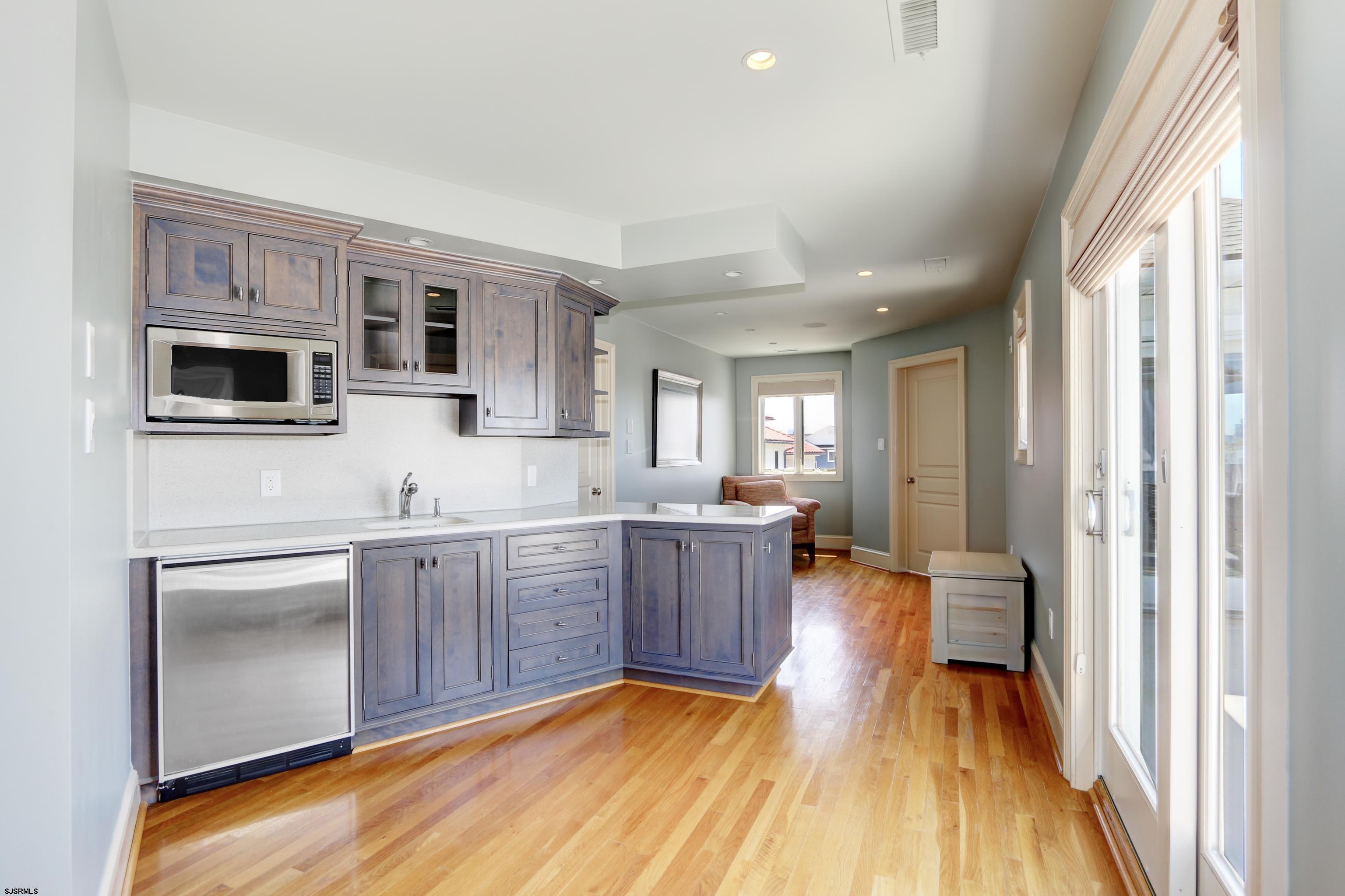 402 20th Street South Brigantine, NJ 08203 - Photo 31 of 59 a kitchen with stainless steel appliances granite countertop a refrigerator a stove top oven a sink dishwasher and white cabinets with wooden floor