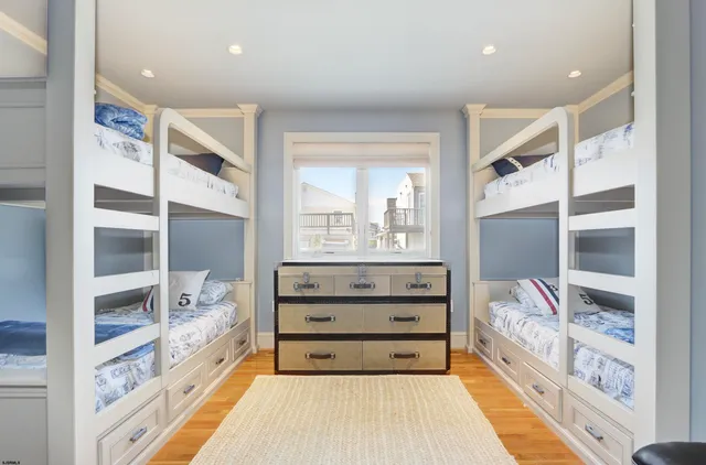 a spacious bedroom with a bed and a flat tv screen on dresser