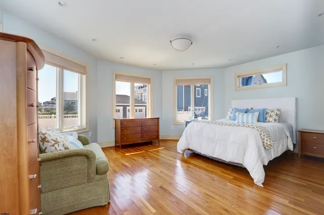 a large bedroom with a bed and wooden floor
