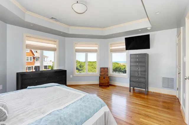 a bedroom with a bed and a flat tv screen on dresser