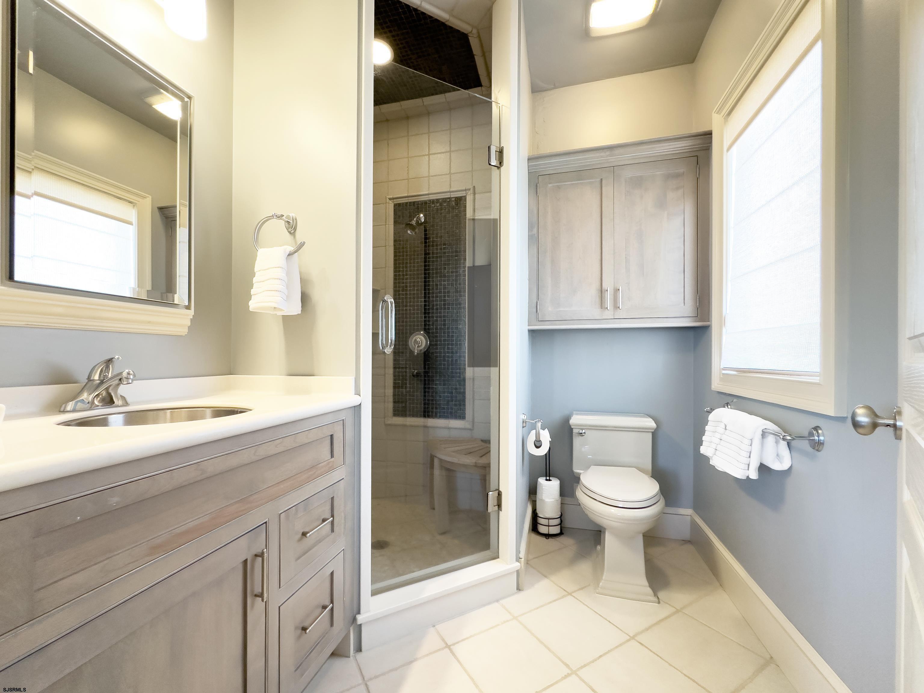 402 20th Street South Brigantine, NJ 08203 - Photo 47 of 59 a bathroom with a granite countertop toilet a sink and a mirror