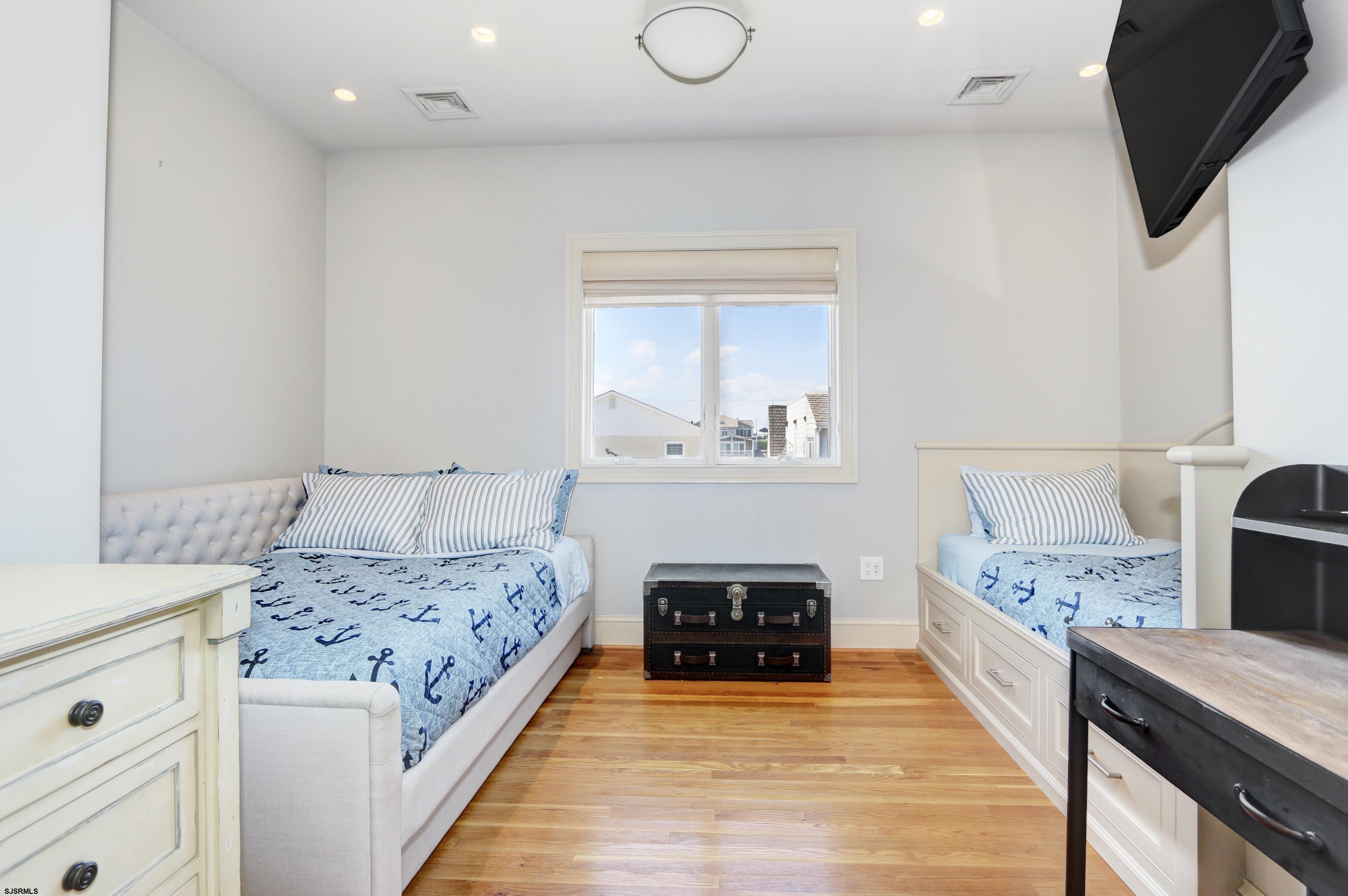 402 20th Street South Brigantine, NJ 08203 - Photo 53 of 59 a spacious bedroom with a bed and a flat tv screen on dresser