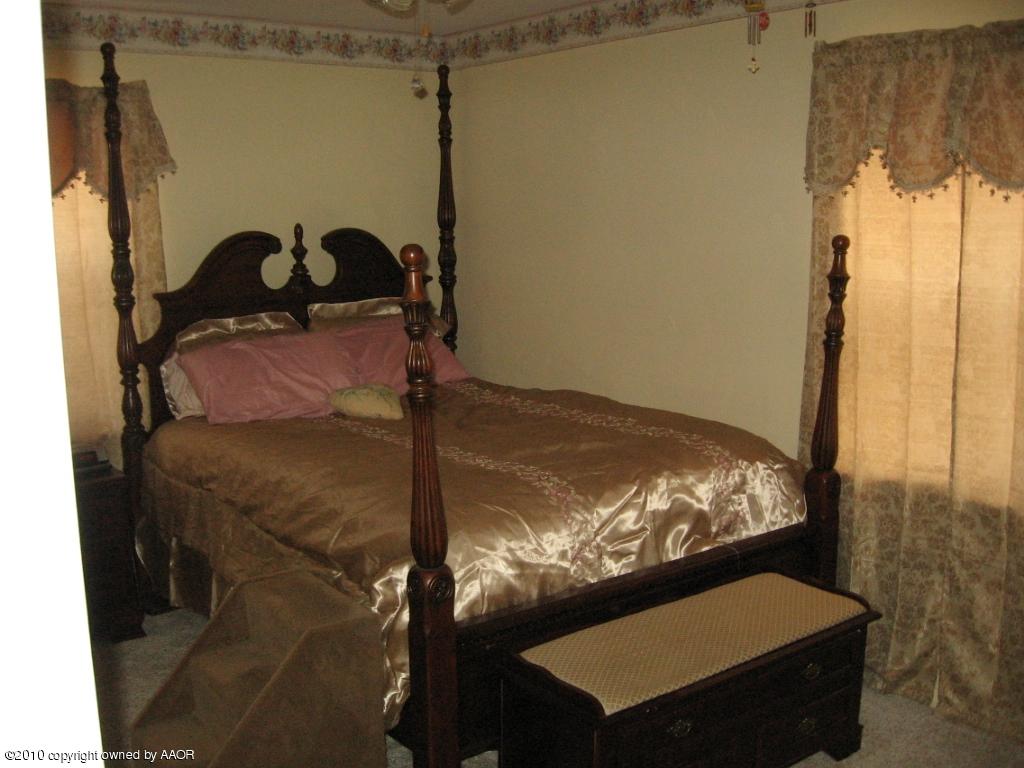 4620 South Hayden Street Amarillo, TX 79110 - Photo 9 of 12 a bed sitting in a bedroom next to a window