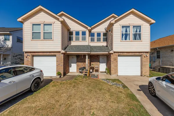 a front view of a house with cars parked