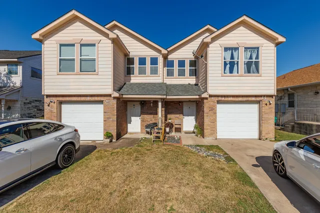 a front view of a house with cars parked