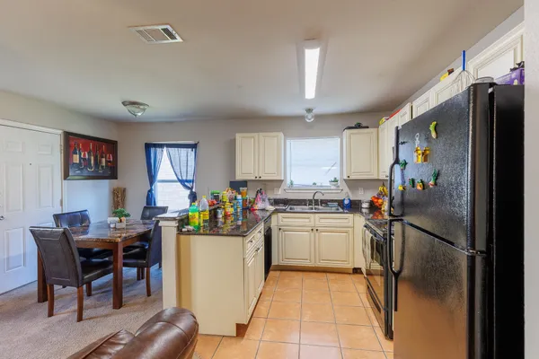 a kitchen with refrigerator and cabinets