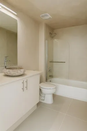 a bathroom with a white toilet sitting next to a bathroom sink and a shower