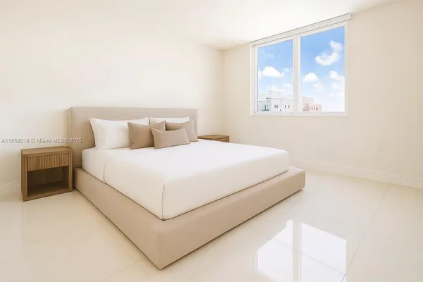 a large bed sitting in a bedroom next to a window