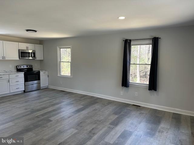 26022 Zion Road Ruther Glen, VA 22546 - Photo 3 of 21 an empty room with wooden floor cabinet and windows