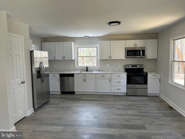 26022 Zion Road Ruther Glen, VA 22546 - Photo 5 of 21 a kitchen with granite countertop white cabinets and stainless steel appliances