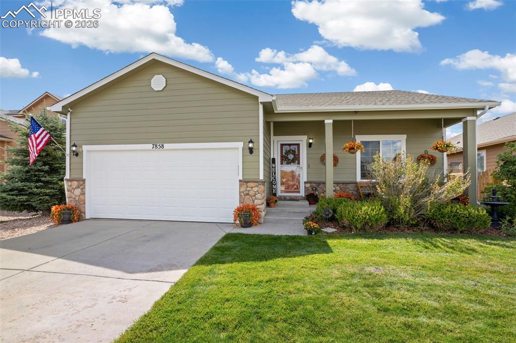 7858 Chasewood Loop Colorado Springs, CO 80908 - Photo 1 of 40 a front view of a house with a yard and potted plants