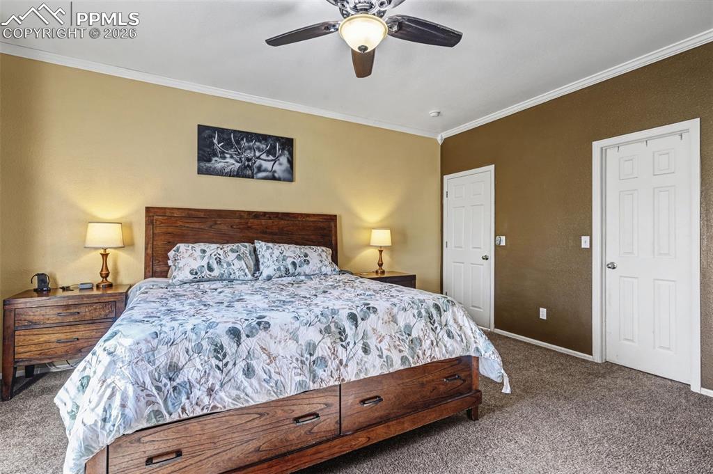7858 Chasewood Loop Colorado Springs, CO 80908 - Photo 14 of 40 a bedroom with a large bed and a chandelier
