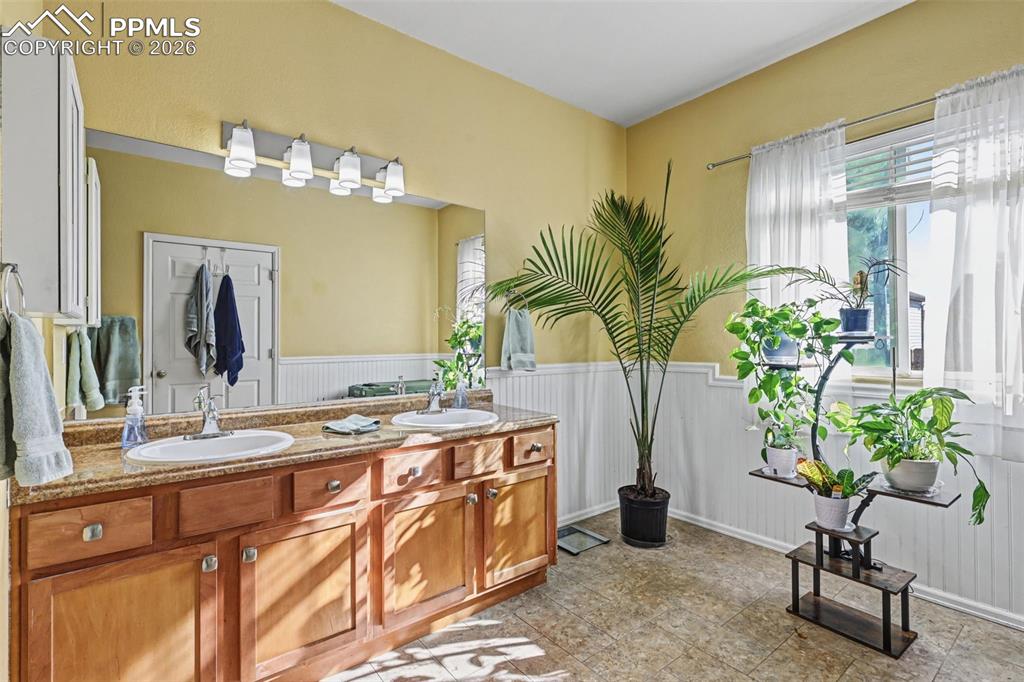 7858 Chasewood Loop Colorado Springs, CO 80908 - Photo 16 of 40 a bathroom with a double vanity sink and a mirror