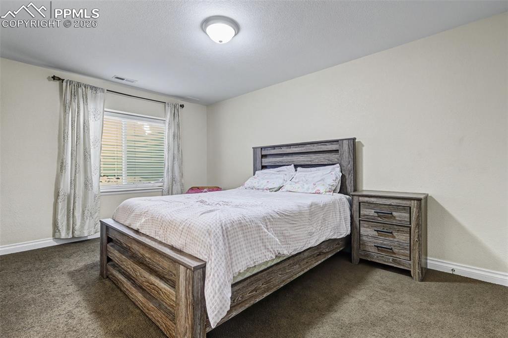 7858 Chasewood Loop Colorado Springs, CO 80908 - Photo 19 of 40 a bed sitting in a spacious bedroom next to a window