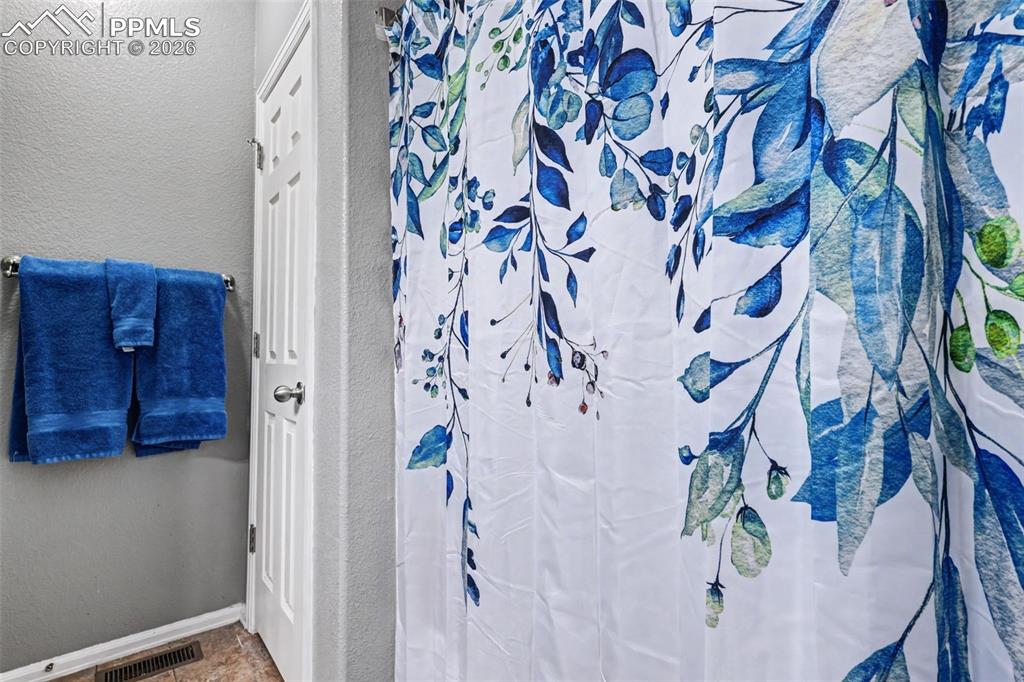 7858 Chasewood Loop Colorado Springs, CO 80908 - Photo 22 of 40 a bathroom with a bathtub and shower curtain
