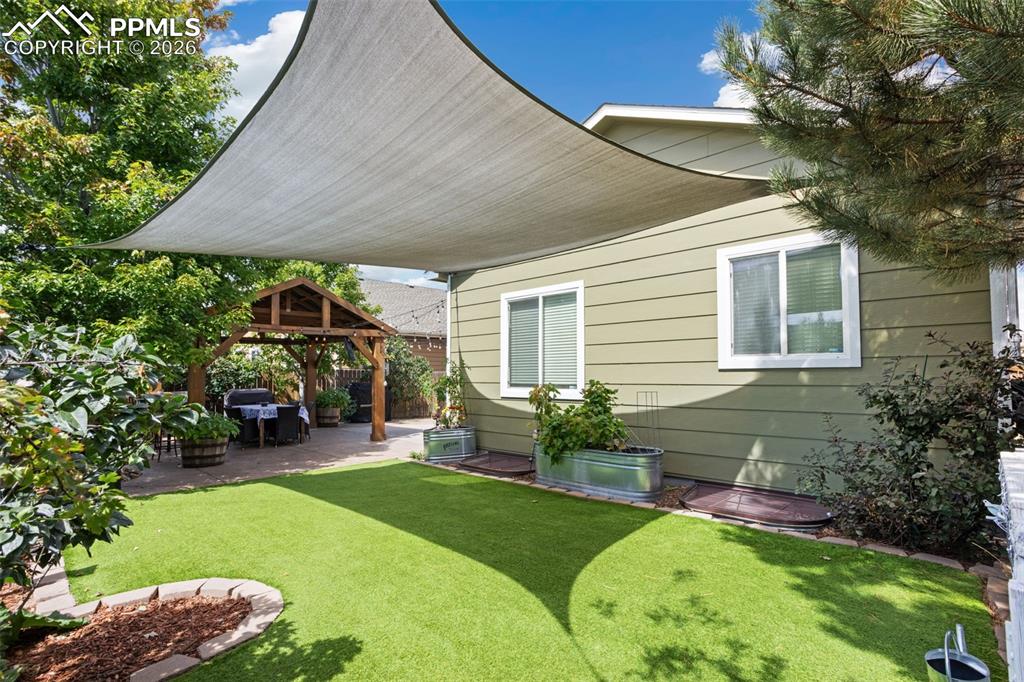 7858 Chasewood Loop Colorado Springs, CO 80908 - Photo 39 of 40 a view of a backyard with table and chairs under an umbrella