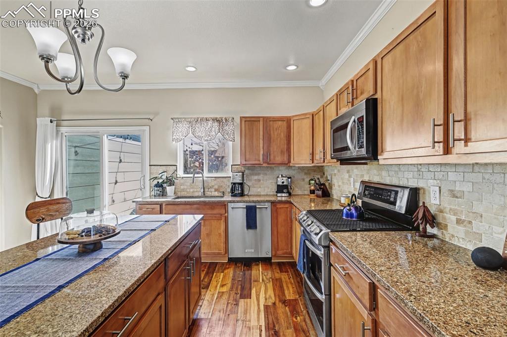 7858 Chasewood Loop Colorado Springs, CO 80908 - Photo 10 of 40 a kitchen with a stove a sink a refrigerator and cabinets