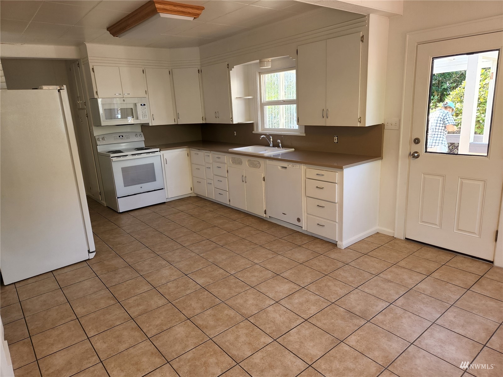 7426 Lower Ridge Road Everett, WA 98203 - Photo 11 of 28 a kitchen with granite countertop white cabinets and white appliances
