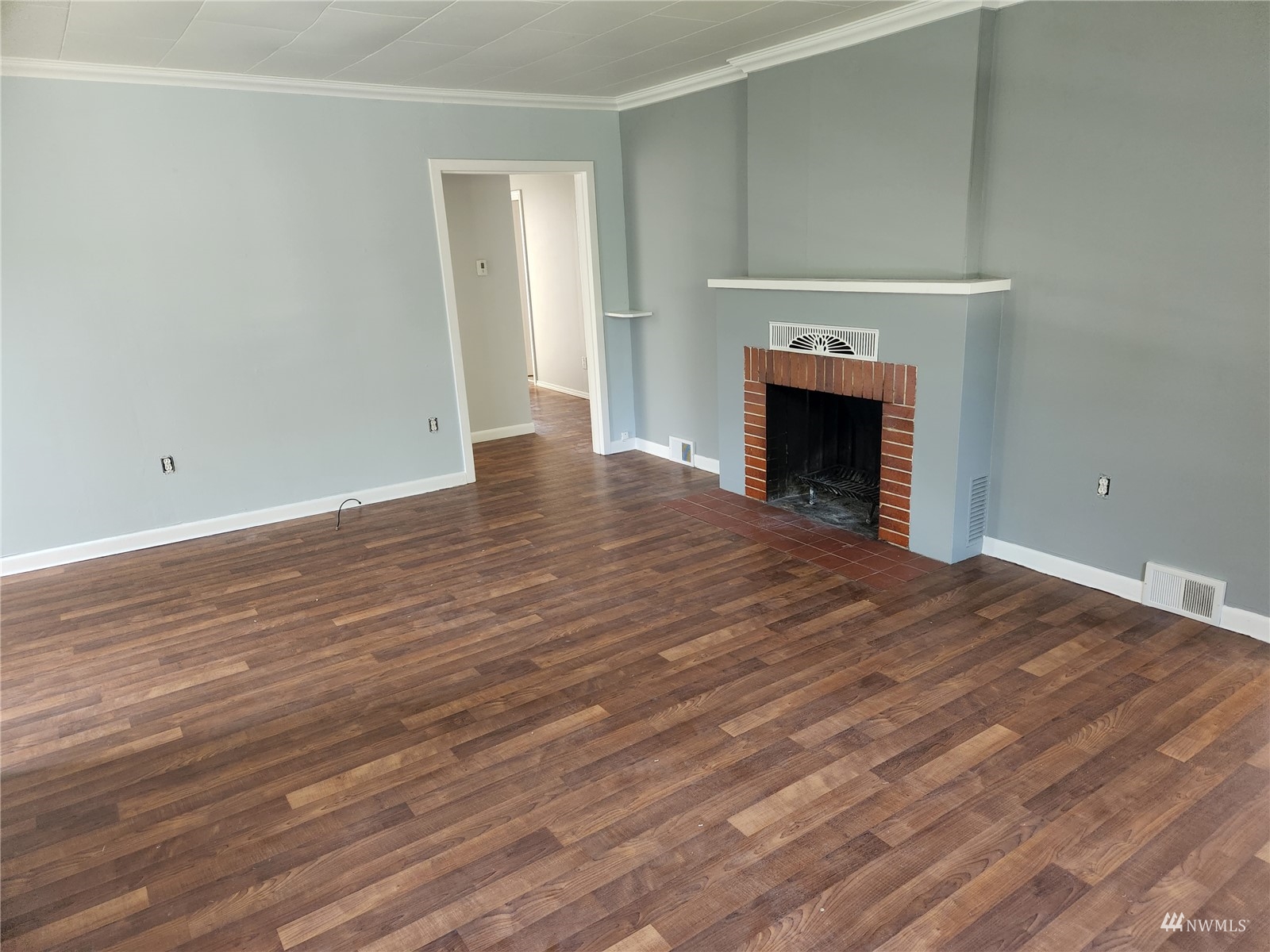 7426 Lower Ridge Road Everett, WA 98203 - Photo 4 of 28 an empty room with wooden floor and a fireplace