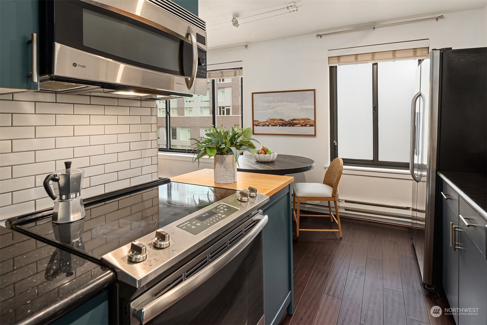 1105 Spring Street, Unit 503 Seattle, WA 98104 - Photo 7 of 18 a kitchen with stainless steel appliances granite countertop a sink a stove and a refrigerator