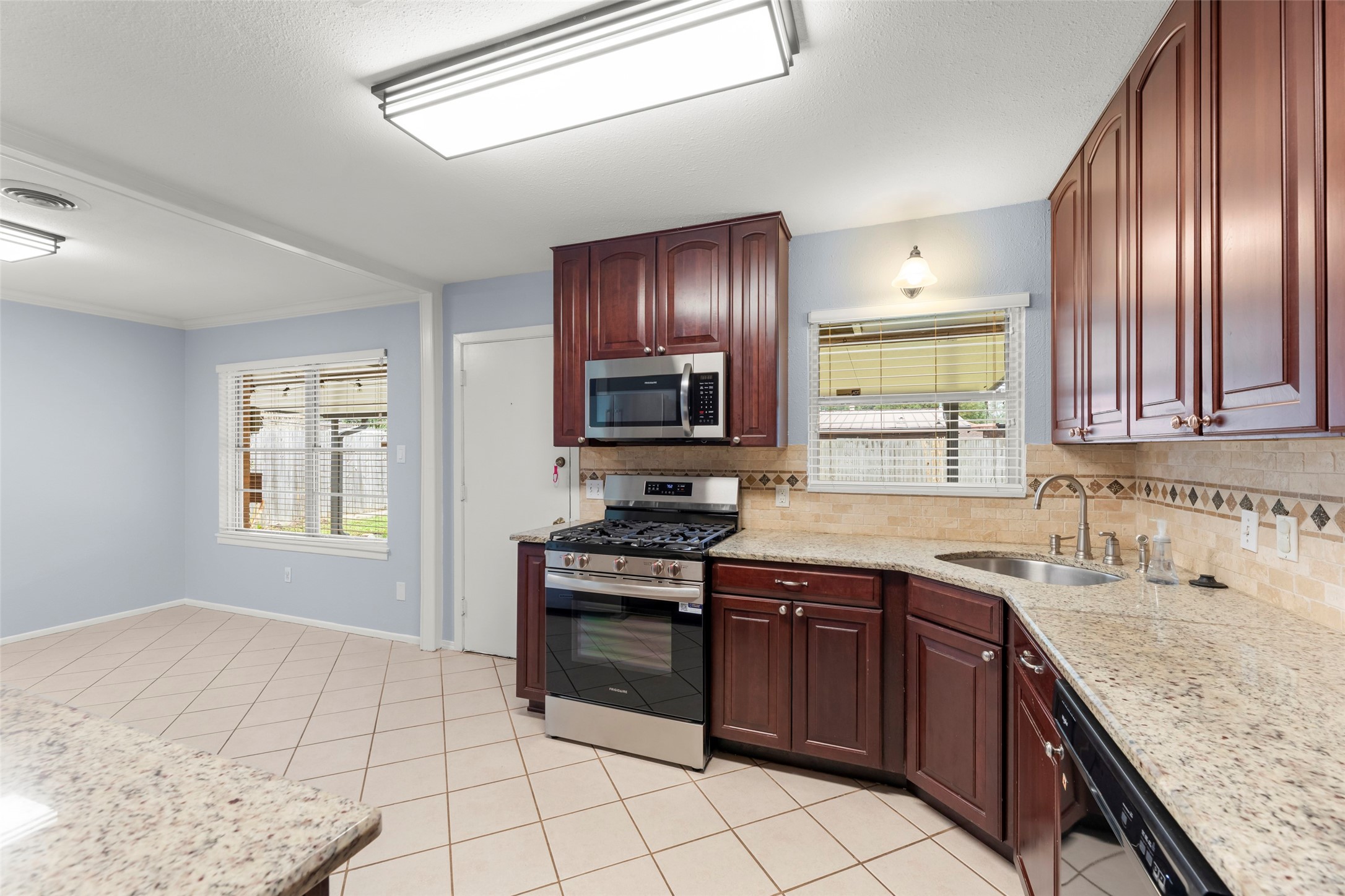 6148 Indigo Street Houston, TX 77074 - Photo 27 of 37 a kitchen with a stove sink and cabinets