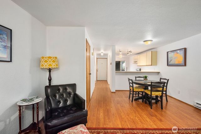 a living room with furniture and a dining table with wooden floor