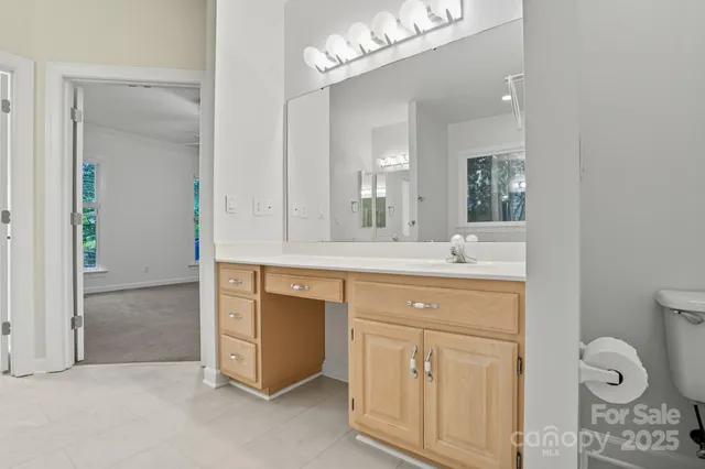 a bathroom with a granite countertop sink toilet a large mirror and shower