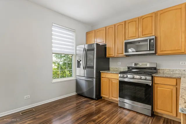a kitchen with granite countertop wooden floors stainless steel appliances and sink