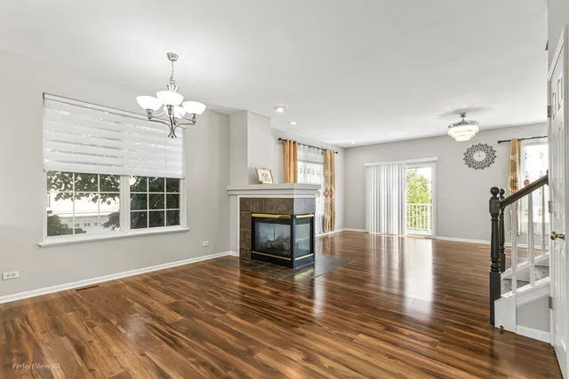 a view of empty room with wooden floor fireplace and window