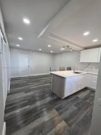 a kitchen with kitchen island white cabinets and stainless steel appliances