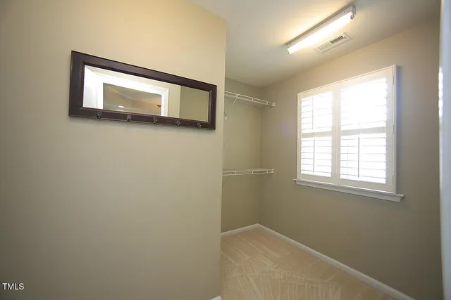 a view of a small space with wooden floor and a window